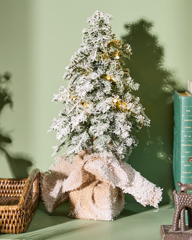 Beleuchteter Weihnachtsbaum mit Sackleinensockel