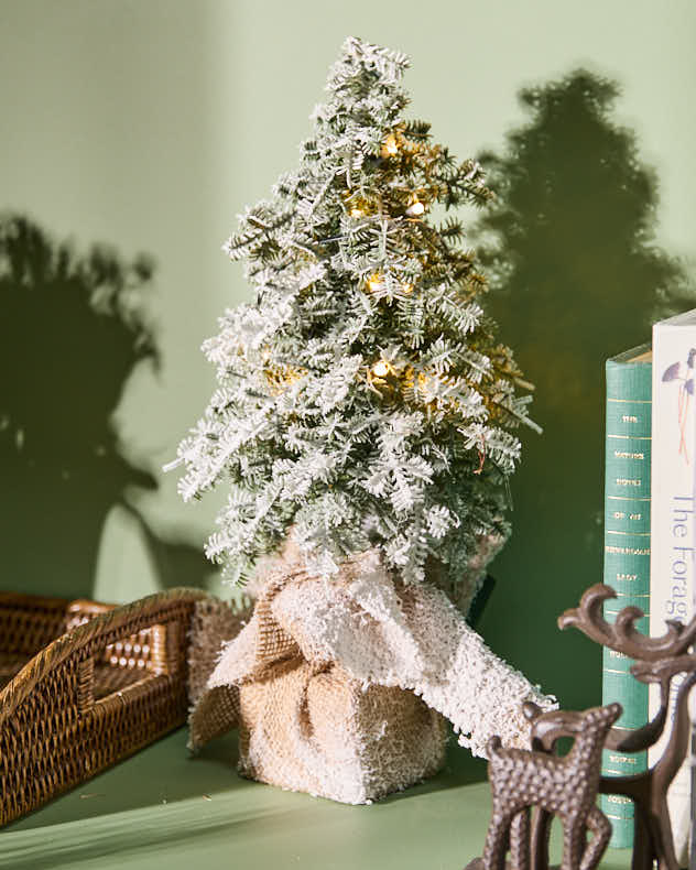 Beleuchteter Weihnachtsbaum mit Sackleinensockel