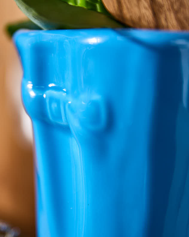 Kleine und große Blumentöpfe in leuchtend blauen Gummistiefeln
