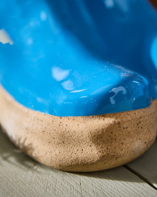 Kleine und große Blumentöpfe in leuchtend blauen Gummistiefeln