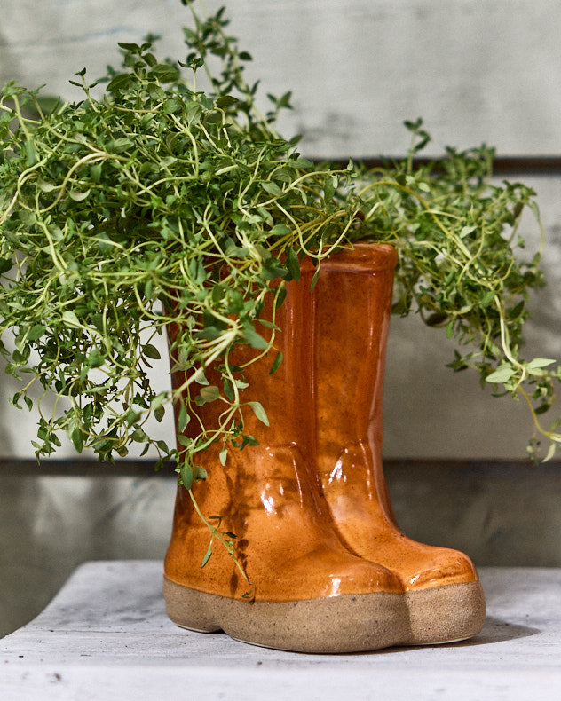 Petits et grands pots de fleurs orange en forme de bottes en caoutchouc