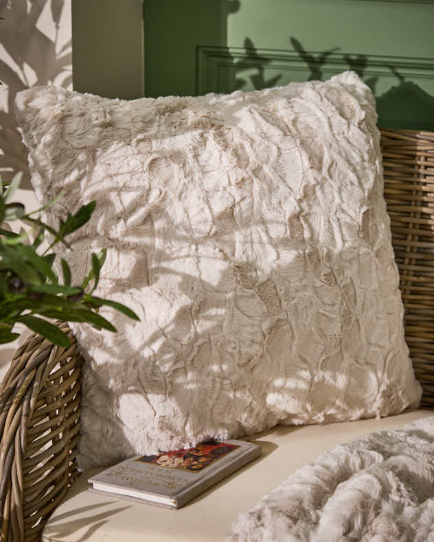 Kollektion aus cremefarbenen, strukturierten Kissen und Decken