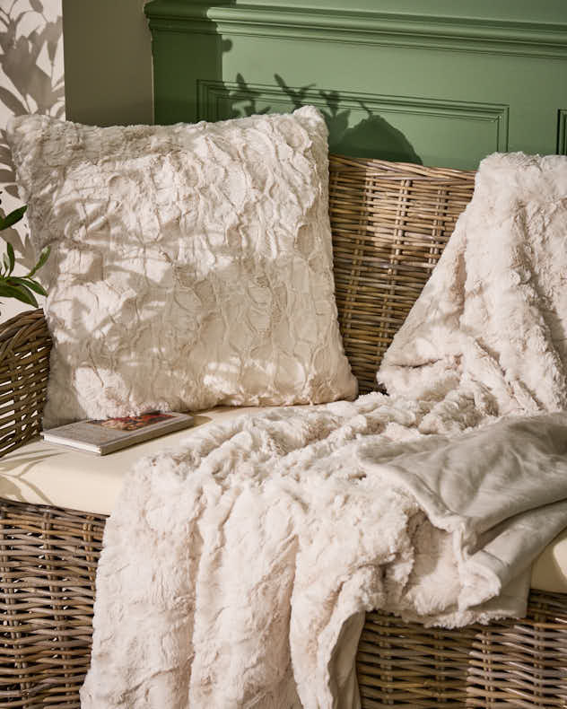 Kollektion aus cremefarbenen, strukturierten Kissen und Decken