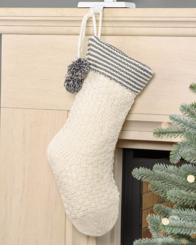 White knit stocking hanging on mantle