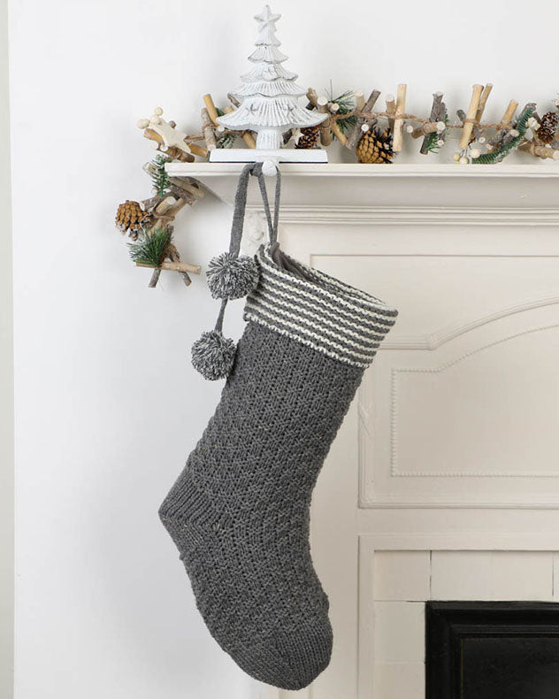 Grey chunky knit stocking hanging on mantle
