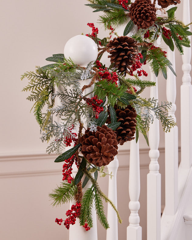 green red pinecone garland on banister
