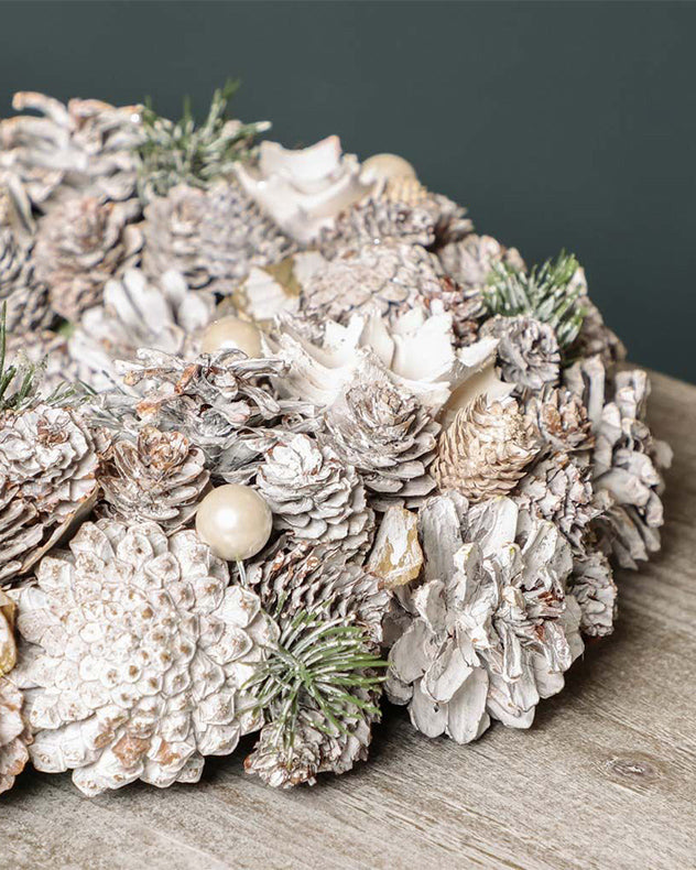 Couronne de fleurs givrées et de pommes de pin d'intérieur